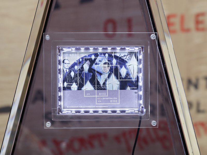 Simon Denny, Blockchain Future States trade fair booth with custom postage stamp: Ethereum [with Linda Kantchev] 2016.  Photo by Hans-Georg Gaul / Courtesy of the artists and Galerie Buchholz Berlin/Cologne/New York.